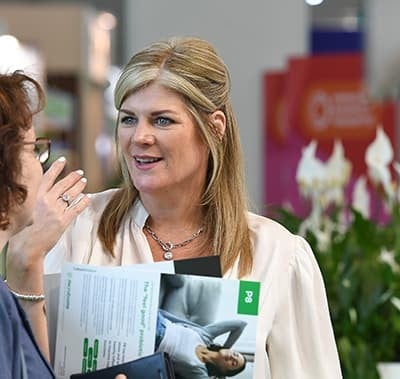 Two visitors speaking at an event